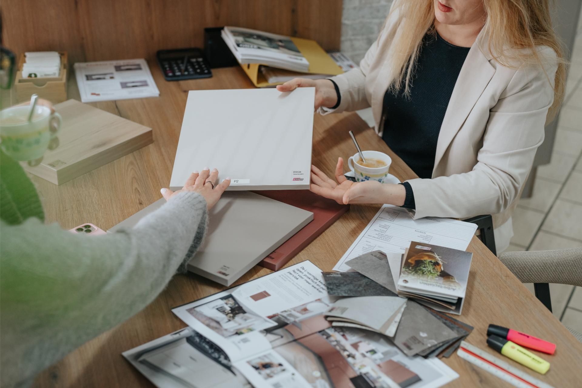 Klant kiest de kleur van haar keuken met stalen in de showroom van J&S Budgetkeukens